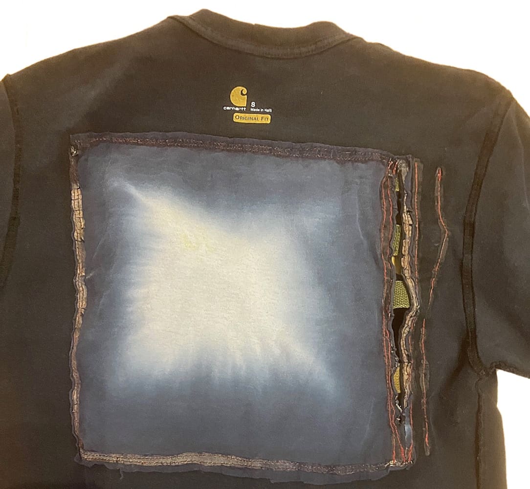 Black t-shirt with a square patch.