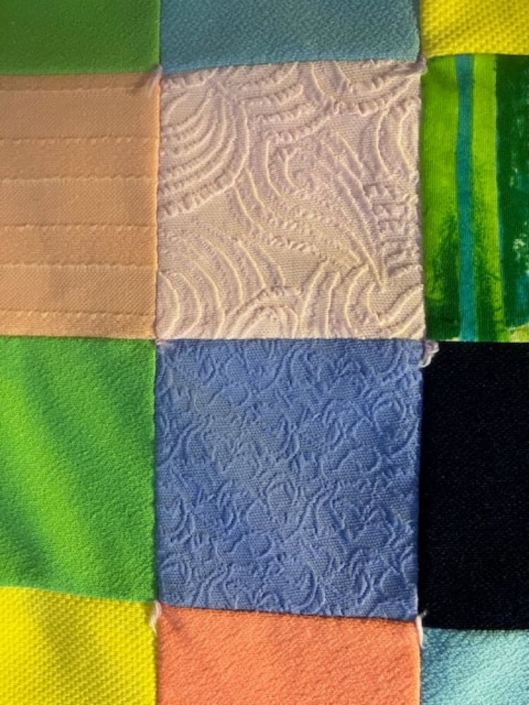A colorful patchwork quilt with various fabric textures and patterns.