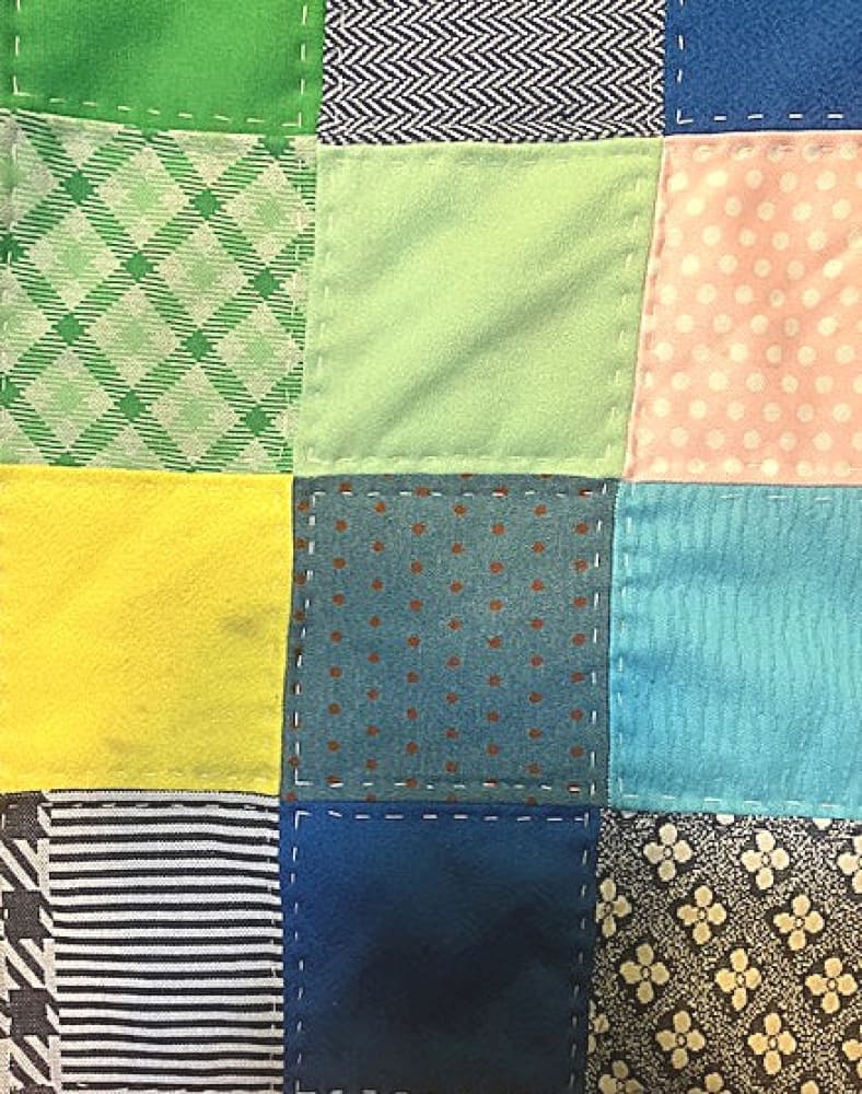 A colorful patchwork quilt with various patterns and textures.