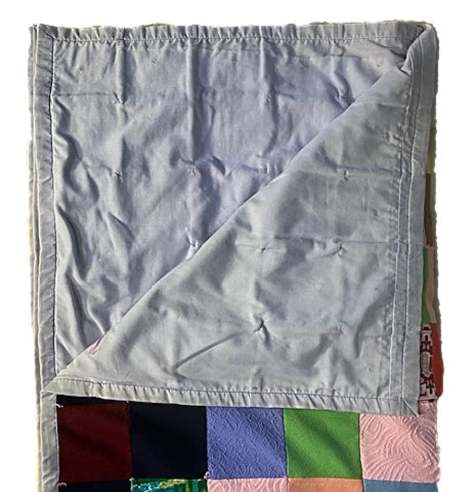 Handmade patchwork quilt with a light blue backing.
