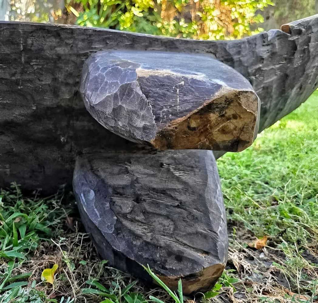 Close-up of handcarved Senufo Crocodile antique bench leg in natural hardwood outdoors