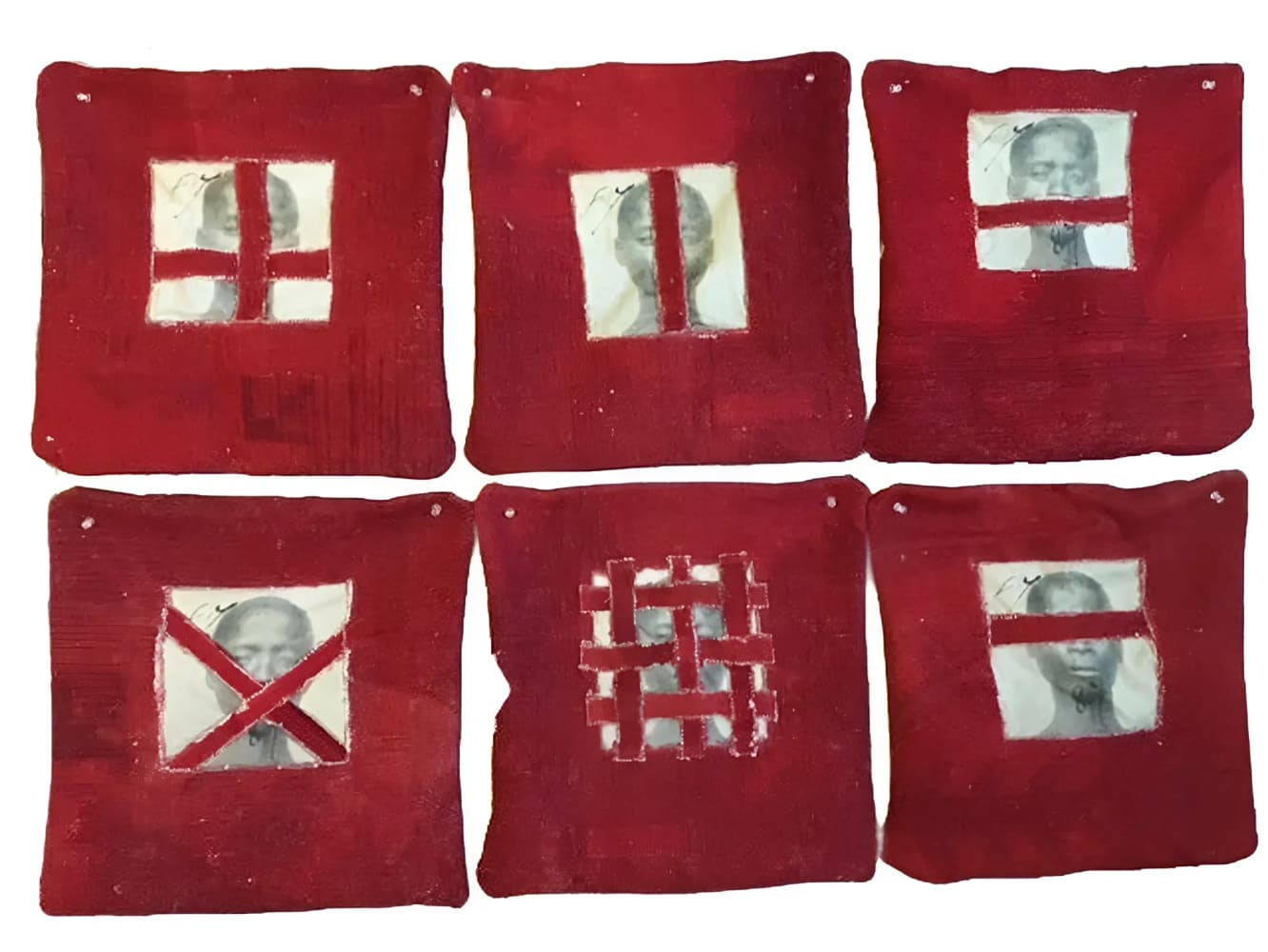 Six red pillows with obstructed portrait images.