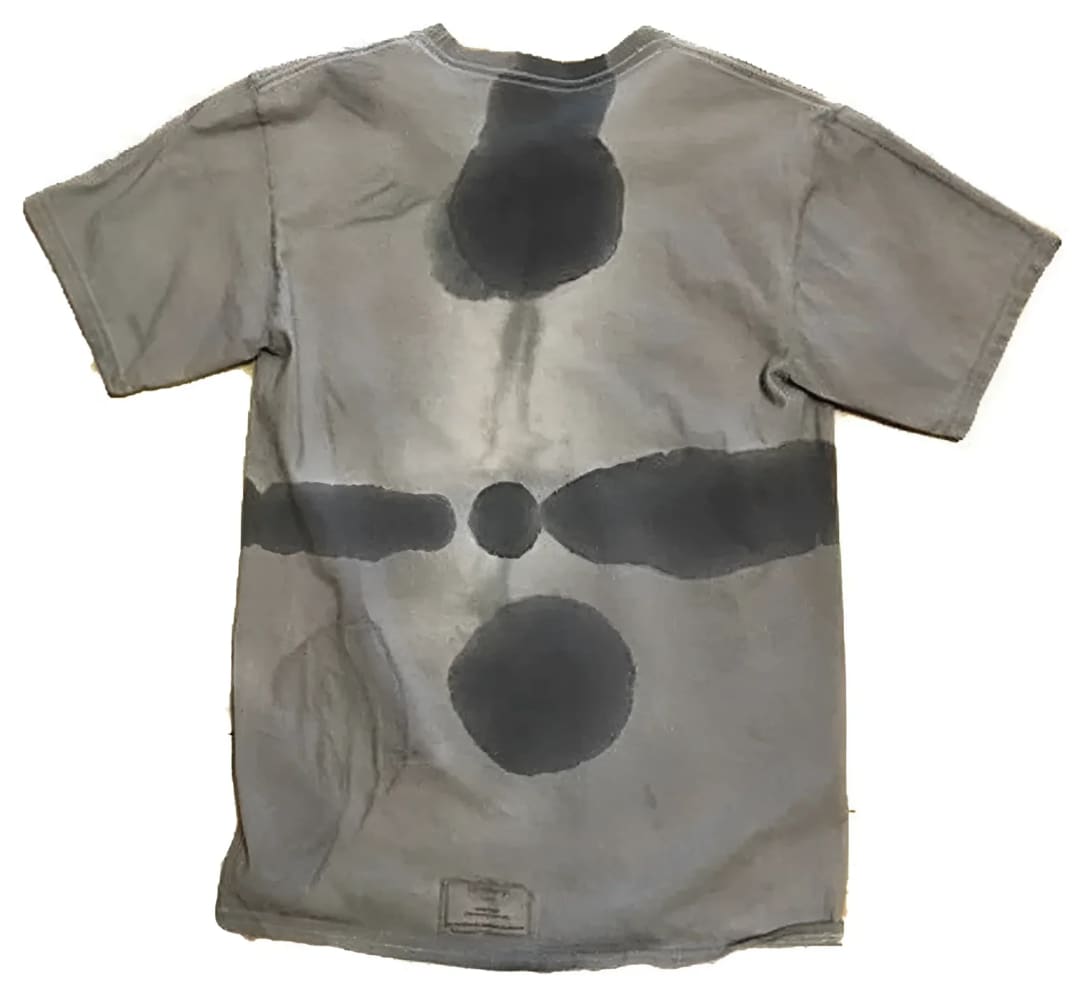 Gray t-shirt with dark circular and linear stains.