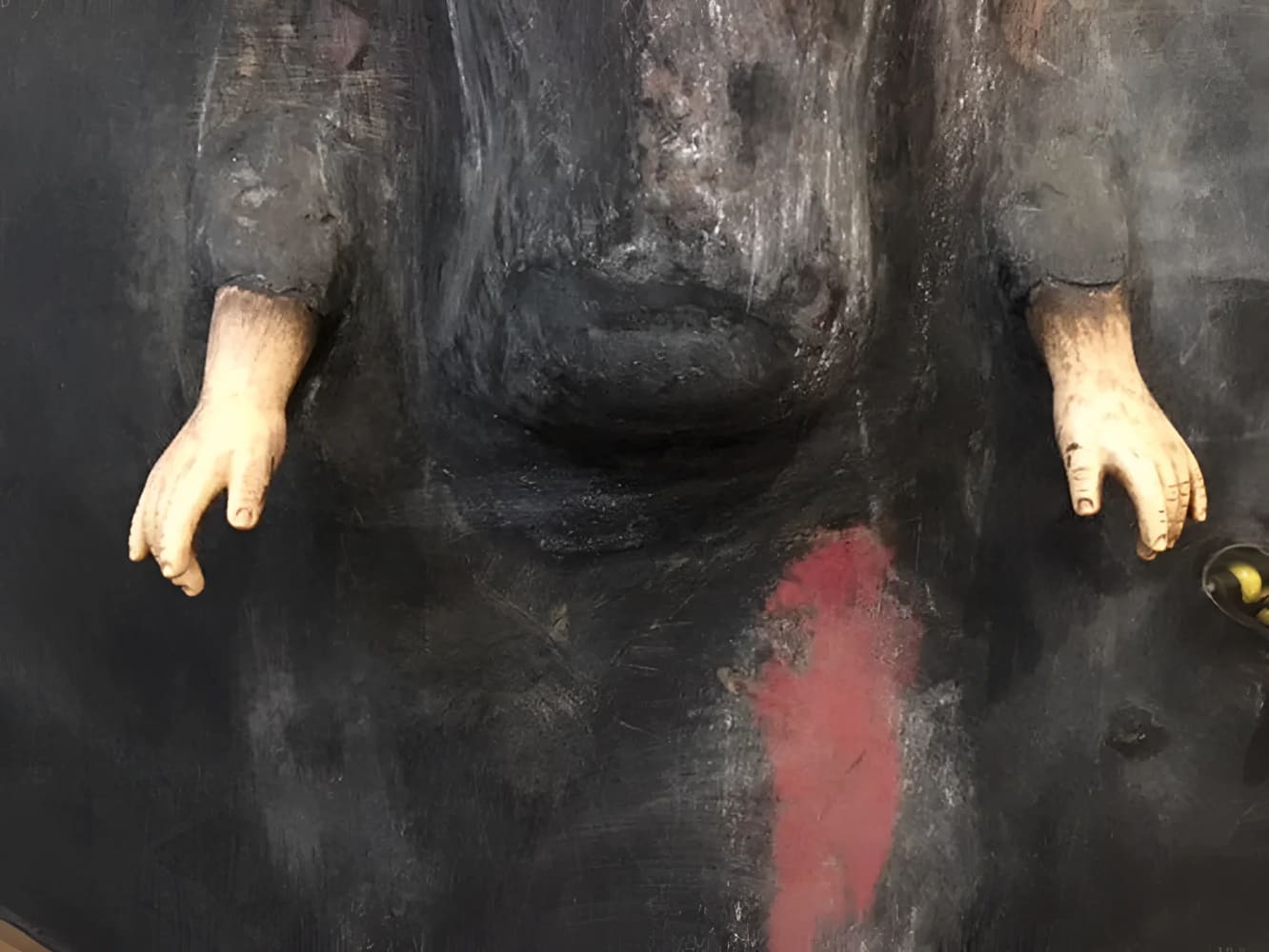 Dark, painted figure with outstretched hands.