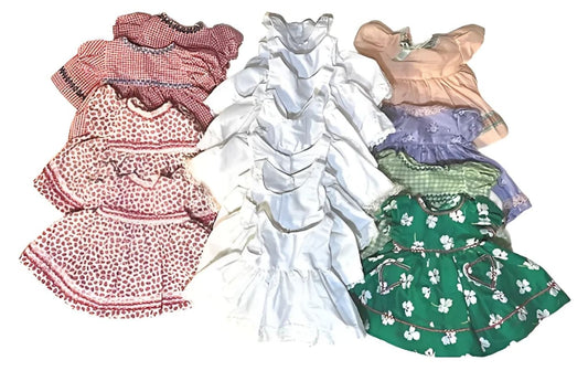 A collection of vintage baby dresses in various colors and patterns.