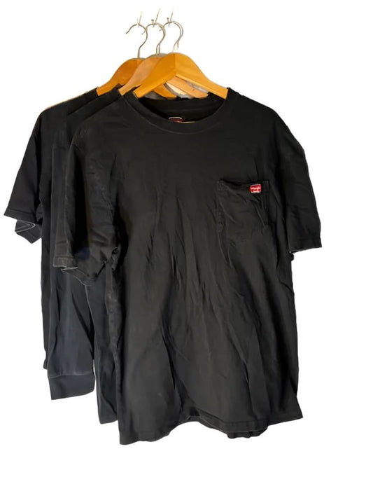 Three black short-sleeved t-shirts on wooden hangers.