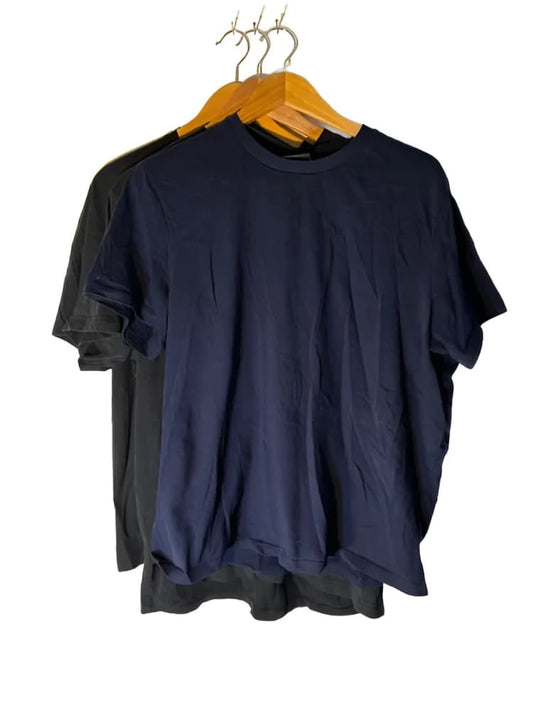 Three short-sleeved t-shirts, one black and two navy blue, hanging on wooden hangers.