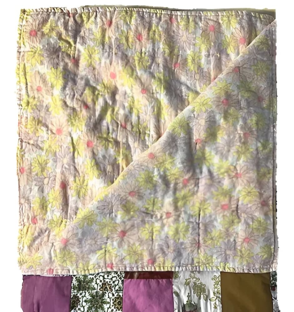A floral patchwork quilt with yellow, pink, and purple patterns.