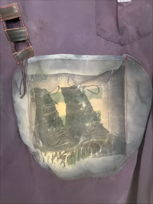 Purple shirt with boot-themed pocket.