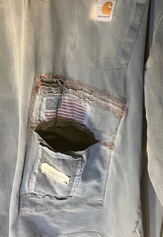 Distressed Carhartt shirt with patched pocket.