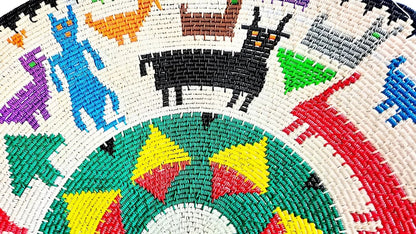 A colorful, woven decorative basket featuring stylized animal and human-like figures.