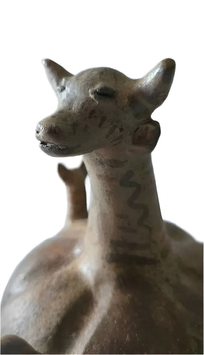 Ancient ceramic vessel in the shape of a stylized animal with a smaller animal on its back.