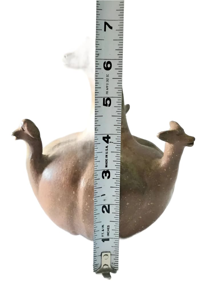 Brown ceramic double-spouted llama effigy vessel.