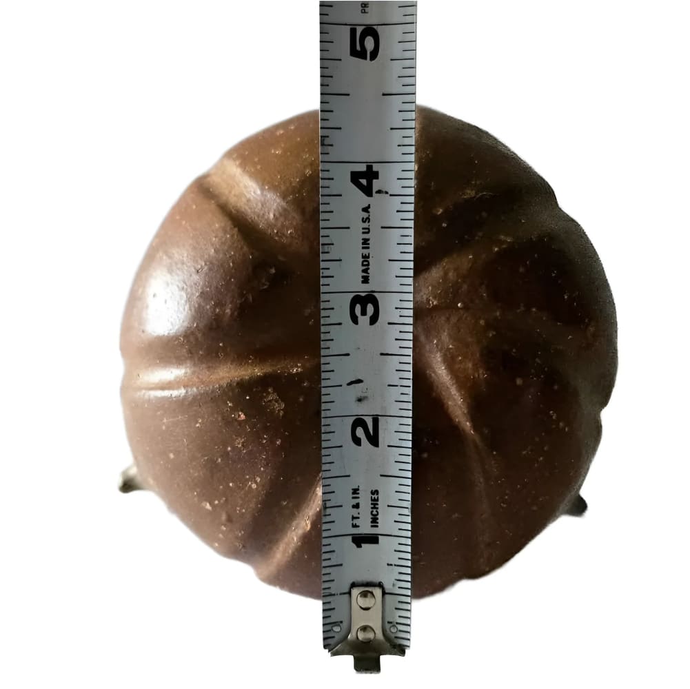 A brown, textured, pumpkin-shaped ceramic or resin decorative item, measured at approximately 4.5 inches in diameter.