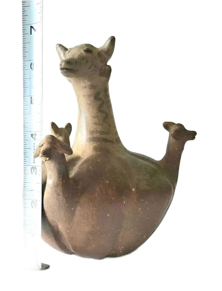 Ceramic vessel in the shape of a horned animal with two smaller animals on its back.