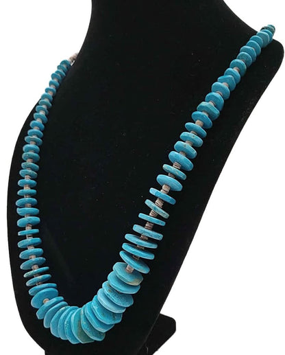 A turquoise disc beaded necklace on a black display.