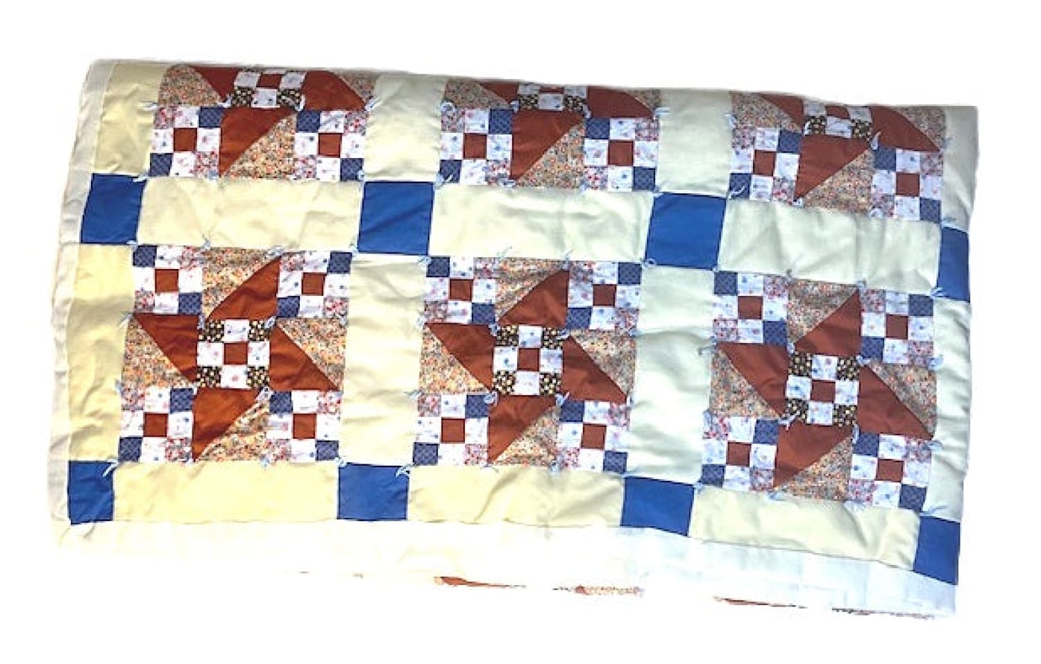 A colorful patchwork quilt with a pinwheel and checkerboard design.
