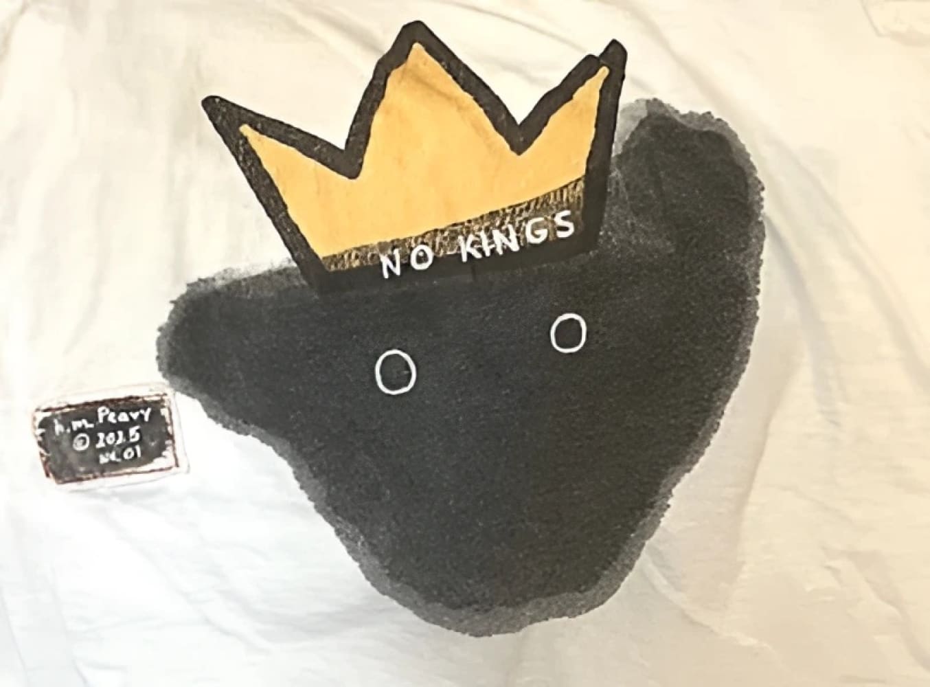 Black bear plush toy with gold crown and ’no kings’ text.