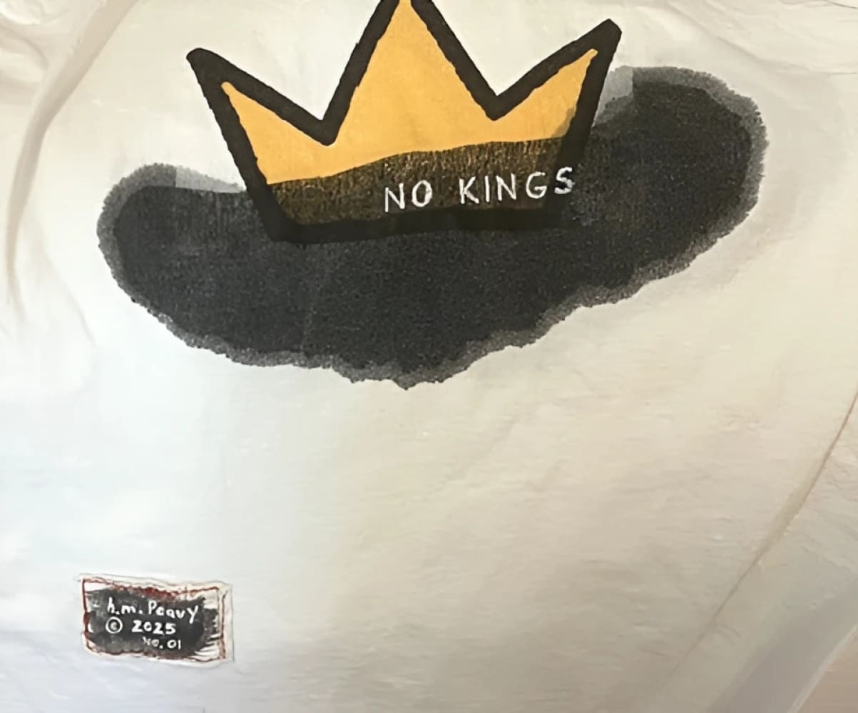 White t-shirt with gold crown and black ’no kings’ text design.