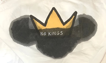 Yellow crown with black text ’no kings’ on white background.