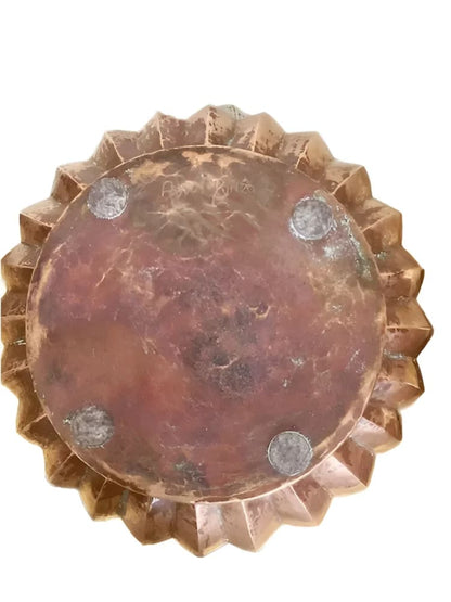 Copper-colored, star-edged bowl with circular base.