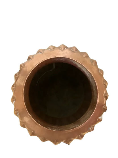 Copper-colored, spiked-rim container.