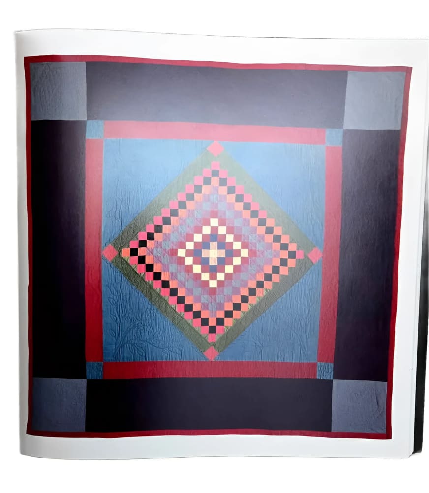 A colorful quilt with a central diamond pattern composed of smaller squares.