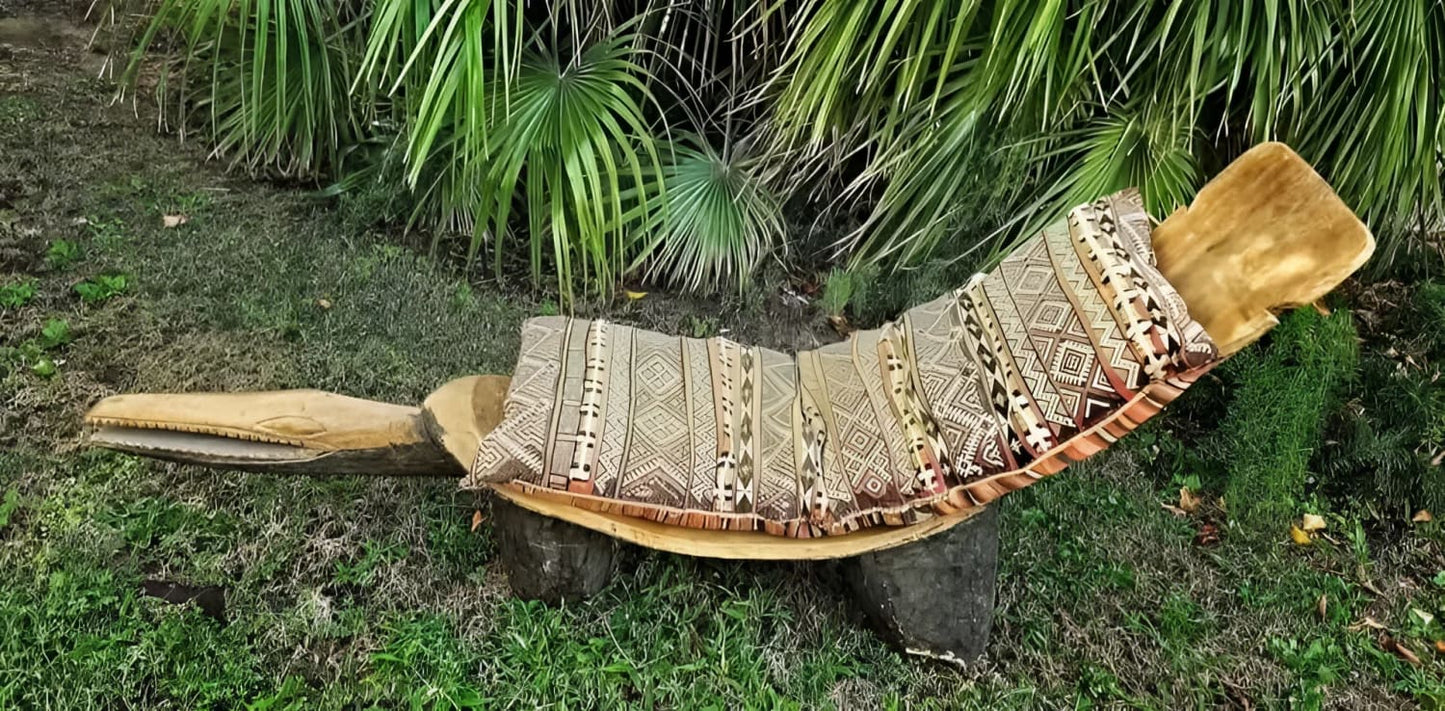 A wooden outdoor lounge chair shaped like an alligator, with a patterned cushion.