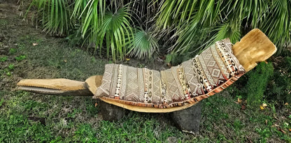 A wooden outdoor lounge chair shaped like an alligator, with a patterned cushion.