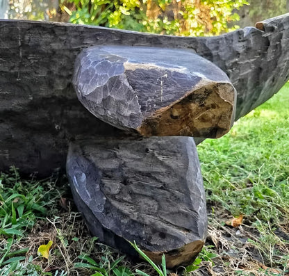 Two rough-hewn, dark wooden pieces with visible chisel marks.