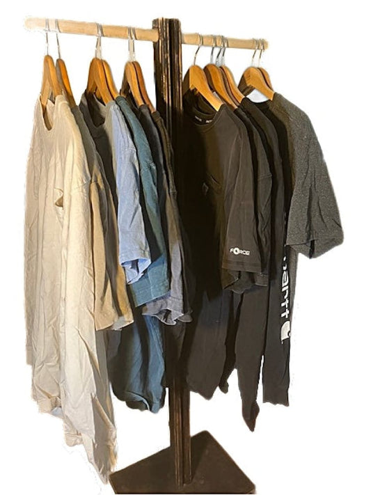 A wooden clothing rack displaying various shirts and pants on hangers.