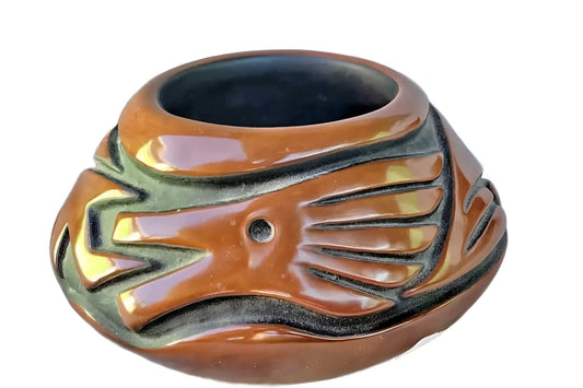 Brown ceramic pot with carved design.