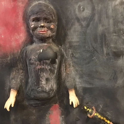 Disturbing, damaged doll sculpture.