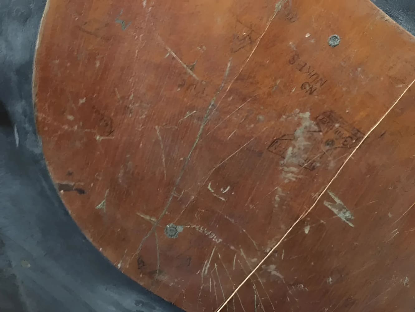 Worn, scratched, and inscribed wooden surface.