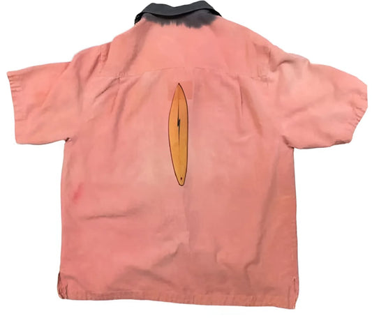Pink short-sleeved shirt with surfboard design.