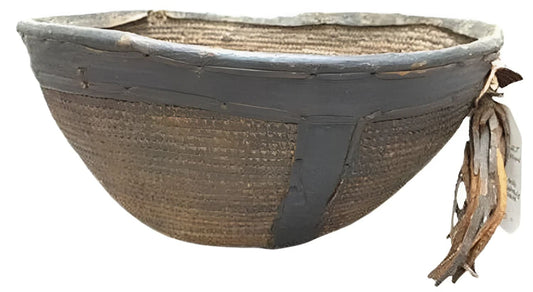 Woven basket with dark trim and attached tags.