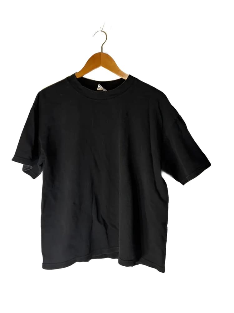 A plain black short-sleeved t-shirt on a wooden hanger.