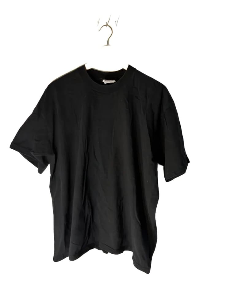 Black short-sleeved t-shirt on a hanger.