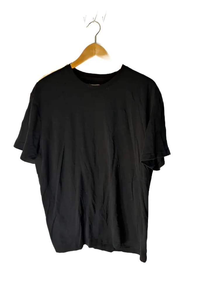 Black short-sleeved t-shirt on a wooden hanger.
