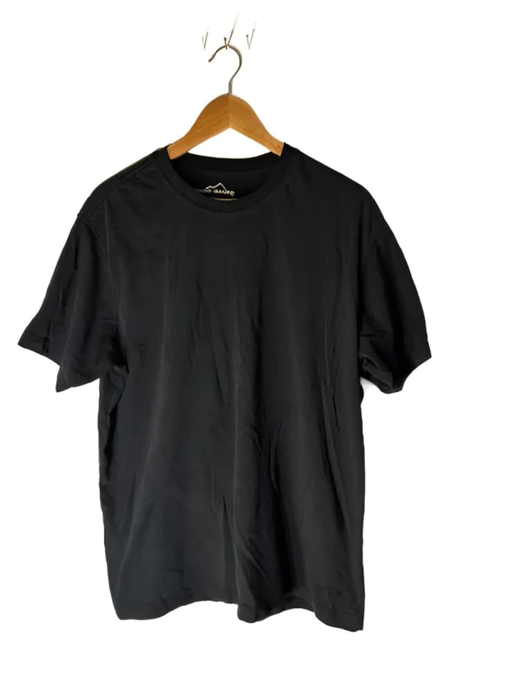 A black short-sleeved t-shirt on a wooden hanger.