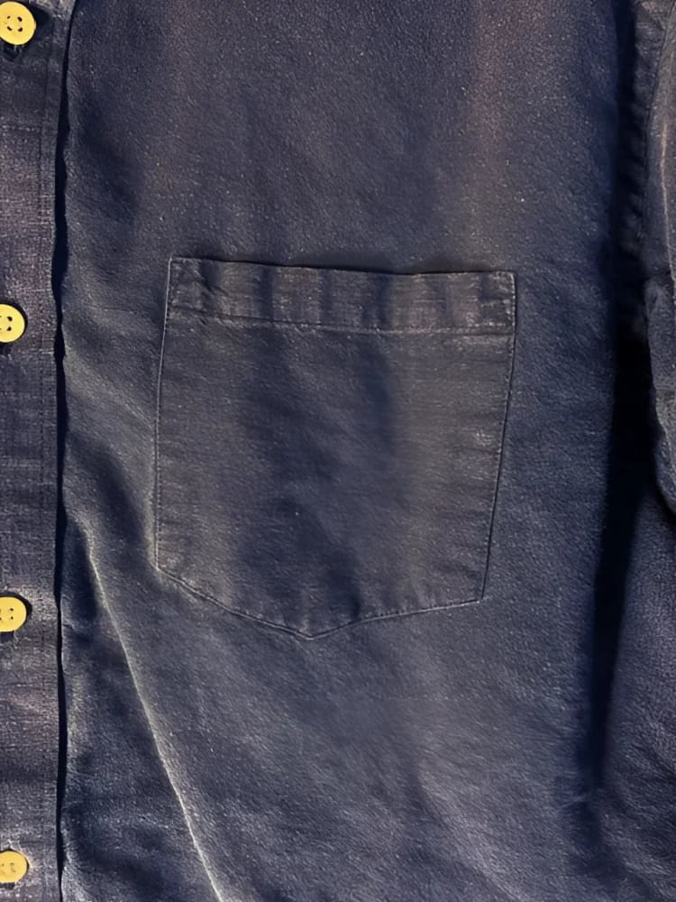 A dark blue denim shirt with a single chest pocket and light-colored buttons.