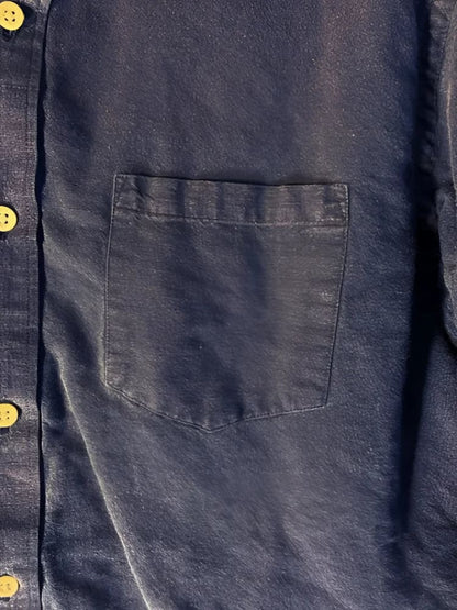 A dark blue denim shirt with a single chest pocket and light-colored buttons.
