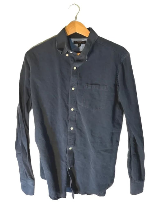 Men’s long-sleeved dark blue button-down shirt with a single chest pocket, hanging on a wooden hanger.