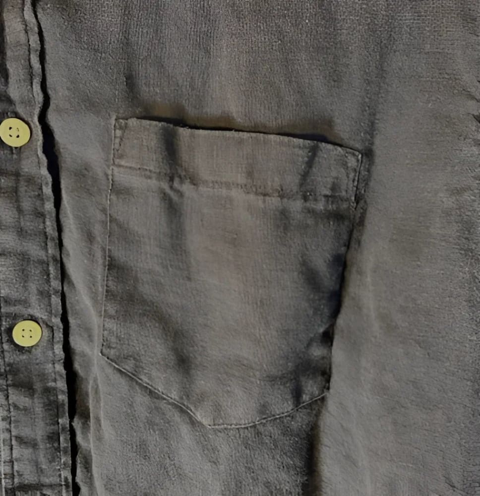Dark gray linen shirt with a single breast pocket and light yellow buttons.