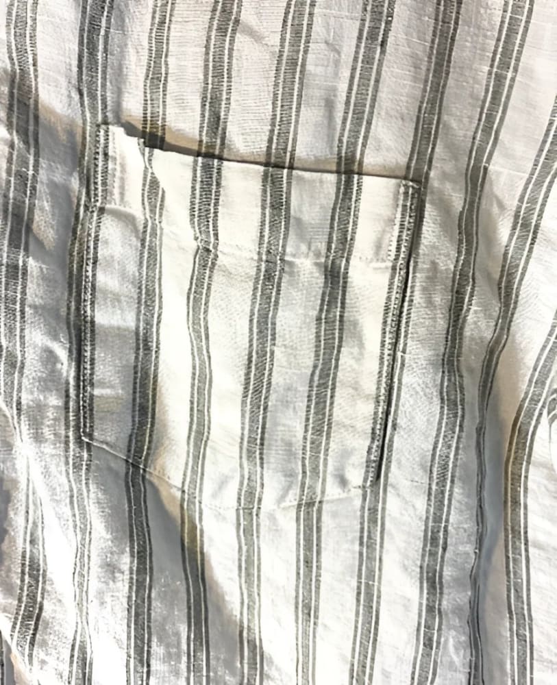 A white and grey striped linen shirt with a chest pocket.