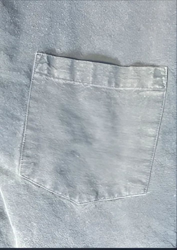 A faded blue denim shirt pocket.