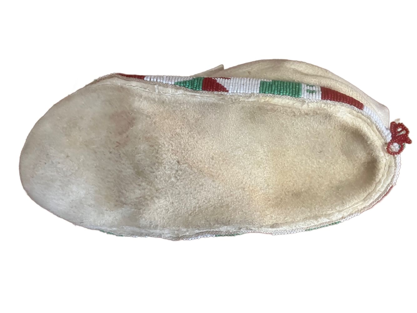 Cream-colored, beaded traditional moccasin.
