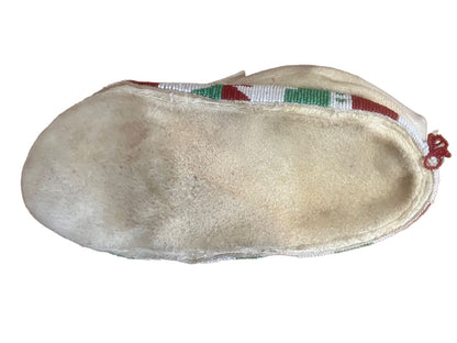Cream-colored, beaded traditional moccasin.