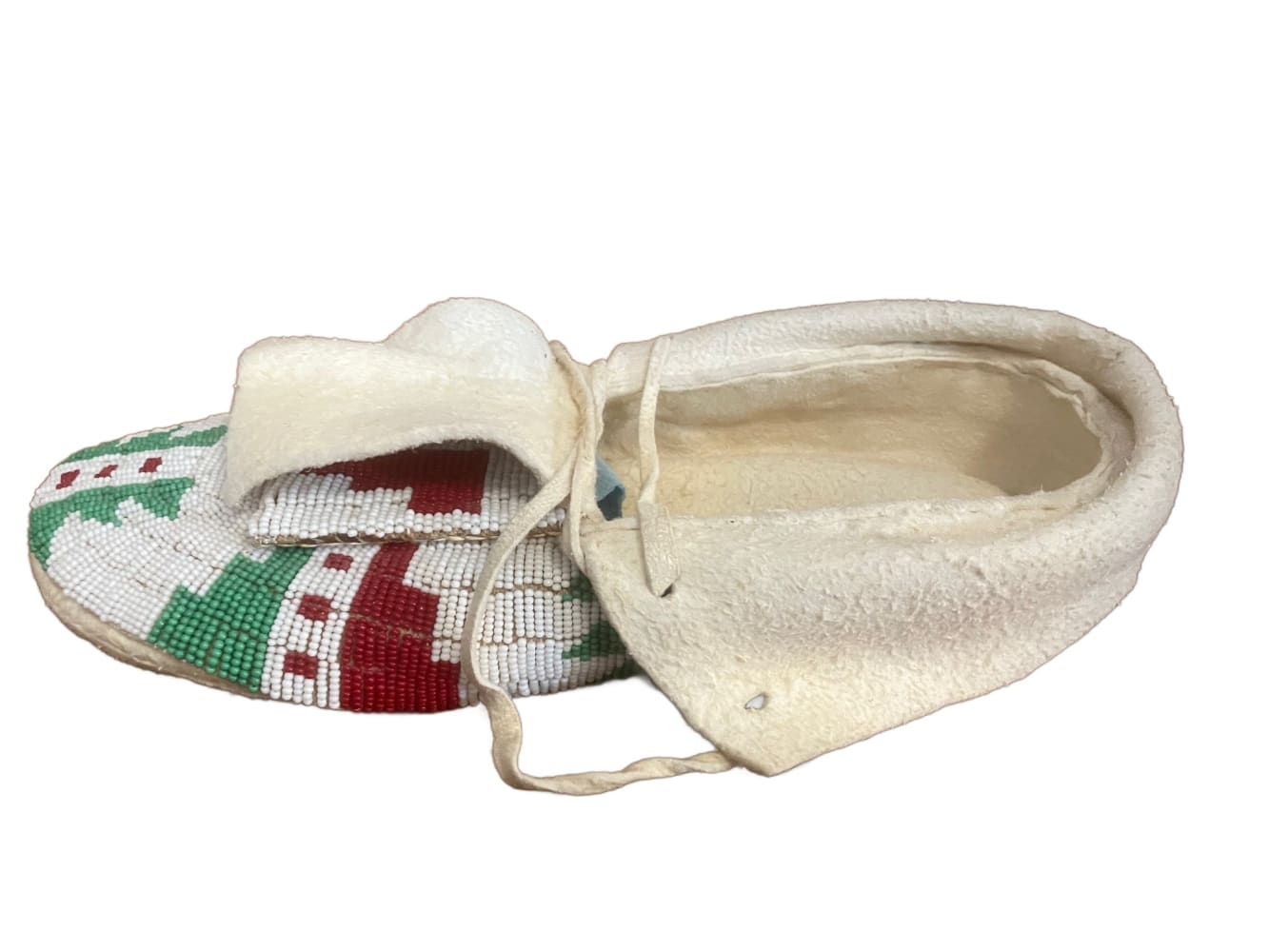 A pair of white, red, and green beaded moccasins with fur trim and laces.