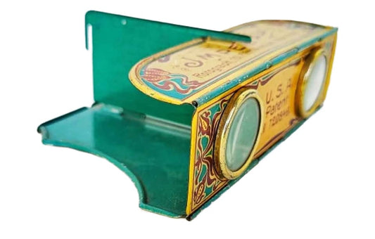 An antique green and gold tin stereoscope with decorative detailing.